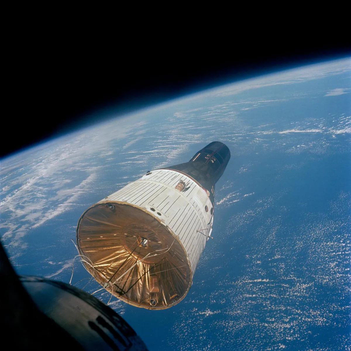 A cone-shaped spacecraft floating high above Earth's clouds